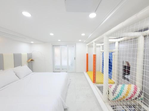 a white bedroom with a bed and a cage at Gapyeong Turu Kids Poolvilla in Gapyeong