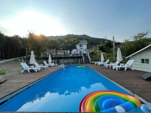 a swimming pool with a rainbow in the middle at Gapyeong Ohneulharu Spa Pension Pet friendly in Oebang-ni