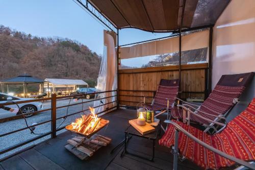 a balcony with chairs and a fire pit on a boat at Jade Byeolbit Caravan in Chuncheon