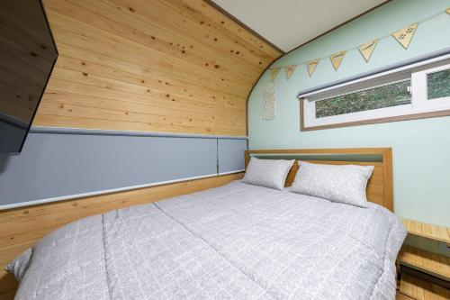 a bedroom in a tiny house with a bed at Jade Byeolbit Caravan in Chuncheon