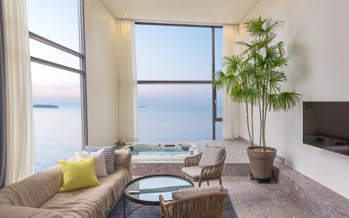 a living room with a couch and a glass table at Byeonsan Barahan Pension in Buan