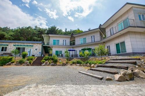 a large building with stairs in front of it at Taean Scenic Pension in Taean