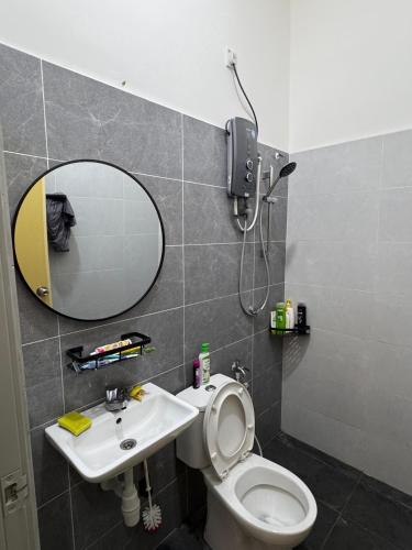 a bathroom with a toilet and a sink and a mirror at Meera Homestay in Malacca