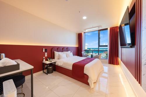 a bedroom with a large bed and a large window at Donghae Sunshine in Mukho-dong