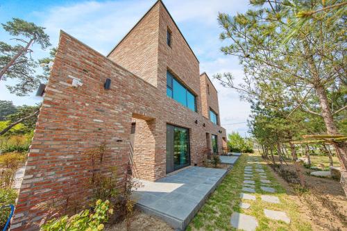 a brick house with a glass entryway at gangreung seuteieoseu in Kangmun