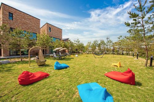 a playground in a yard with chairs and a swing at gangreung seuteieoseu in Kangmun