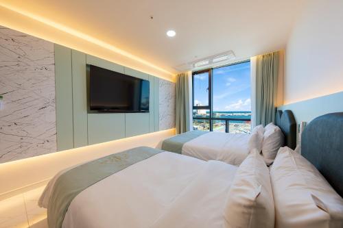 a hotel room with two beds and a large window at Donghae Sunshine in Mukho-dong