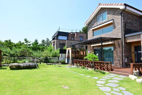 a house with a large yard in front of it at Goseung Luceluna Pension in Yongch'ol-li