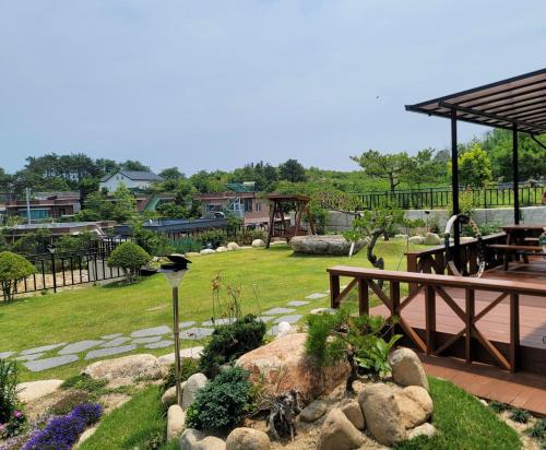 a garden with a picnic table and a bench at Goseung Luceluna Pension in Yongch'ol-li
