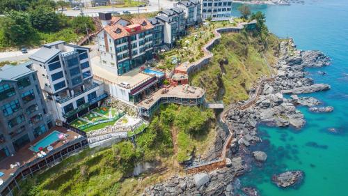 an aerial view of a resort on a cliff next to the water at Samcheok Laon Spa Pension in Samcheok