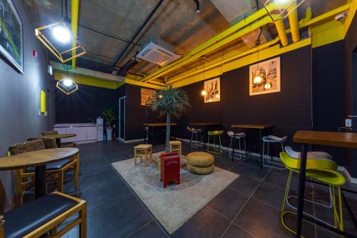 a bar with tables and stools in a room at Samcheok Laon Spa Pension in Samcheok