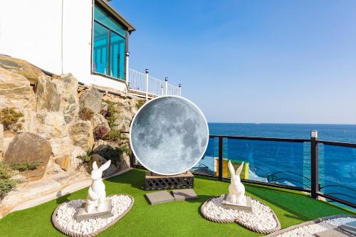 a large moon sculpture on the grass near a building at Samcheok Laon Spa Pension in Samcheok