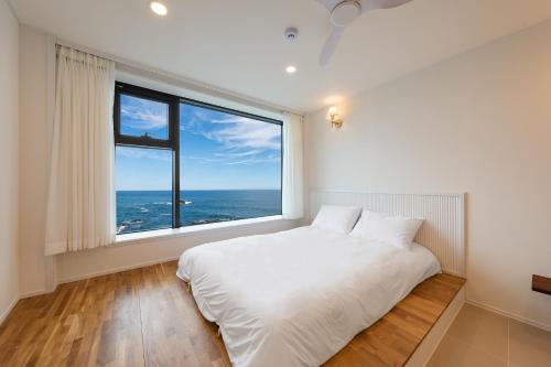 Ένα ή περισσότερα κρεβάτια σε δωμάτιο στο Gangneung Hue Pension Ocean View, Spa, Couple