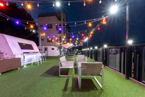 a patio with lights and chairs on a roof at night at Samcheo Tayo Caravan in Samcheok