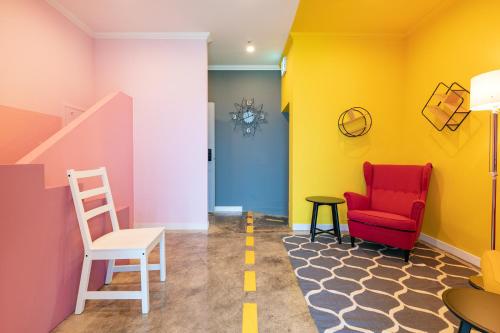 a room with a red chair and yellow walls at Samcheok Laon Spa Pension in Samcheok