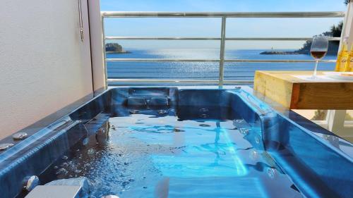 a blue bath tub with a view of the ocean at Taean The sea side Pension in Tohwang-ni