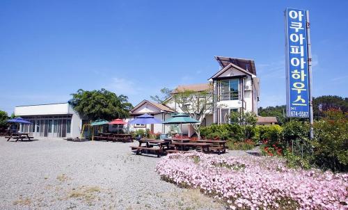 Un restaurante con mesas y sombrillas frente a un edificio. en Aquapia House, en Taean