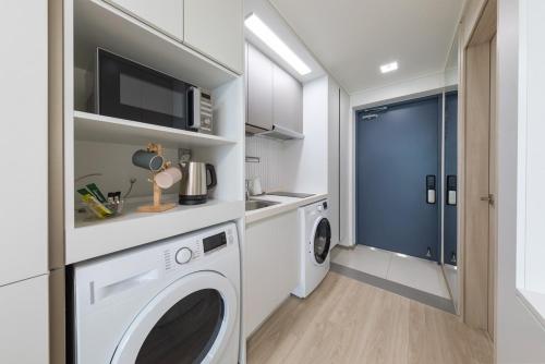a laundry room with a washer and dryer at Sokcho Rianvichae Central in Sokcho