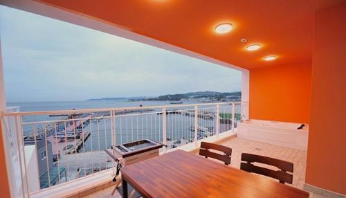 a balcony with a table and a view of the ocean at Gyeongju Zest57 Pension in Gyeongju