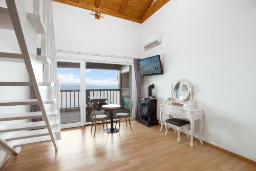 a living room with a staircase and a table and chairs at anmyeondo gold hue pension in Taean