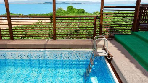 a swimming pool with a view of the water at anmyeondo gold hue pension in Taean