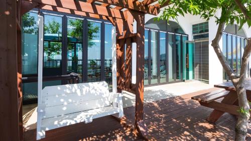 a white bench sitting on a porch with windows at anmyeondo gold hue pension in Taean