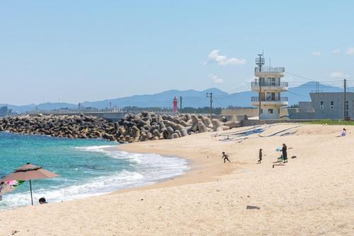 a group of people on a beach near the ocean at Gangneung Blanc Beach Pension in Gangneung