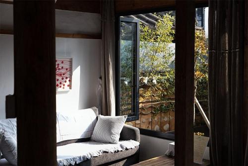 a living room with a couch and a large window at Luwa Private Pension in Jeonju