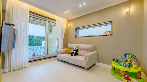 un salon avec une chaise et une fenêtre dans l'établissement Gyeonju Coo n eye kids poolvilla, à Gyeongju