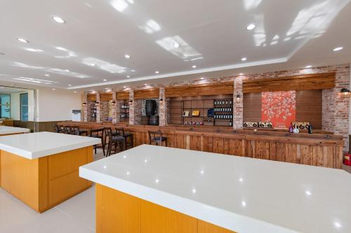 a restaurant with a bar with white counter tops at Gochang Hwangto Bokbunja Pension in Gochang 