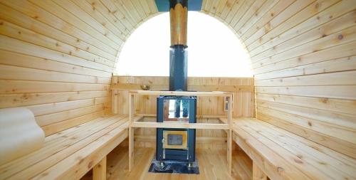 a wooden sauna with a stove in the middle at Buan Byeonsanbando Noeulbit Hill Pension in Buan