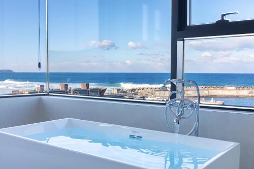 a bath tub with a view of the ocean at Donghae Staypear471 in Donghae
