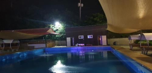 an empty swimming pool at night with a building and lights at Jeongeup Geumgang Duseungsan Glamping in Jeongeup