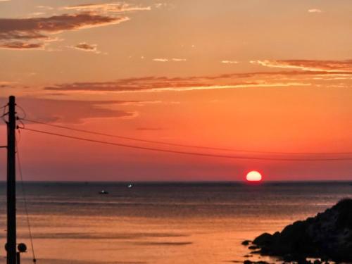 a sunset over the ocean with the sun in the sky at Goseong Stay Naru in Goseong
