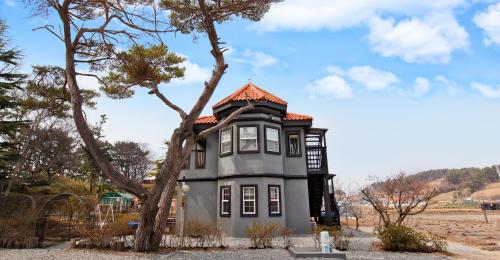 a small house with a tree in front of it at Taean janggog pension in Kwik-kol