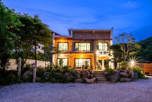 a large house with some rocks in front of it at Ganghwa Bridge House in Incheon