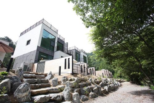 ein Haus auf einem Hügel mit Felsen in der Unterkunft Yeongwol Hieori Pension in Yeongwol