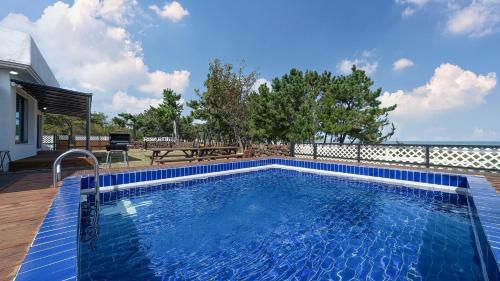 a swimming pool in a yard with a house at Pohang The One Sunrise Pension in Pohang
