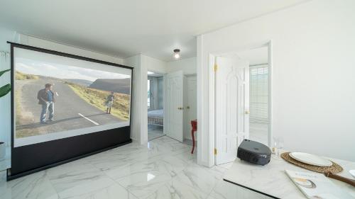 a room with a large screen with a man on a road at Pohang The One Sunrise Pension in Pohang