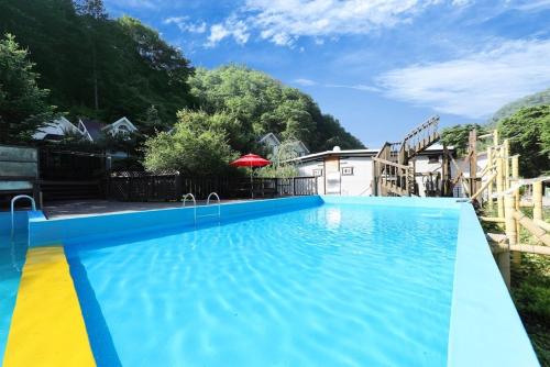 a large blue swimming pool in a yard at Gapyeong Attirance Pension in Gapyeong