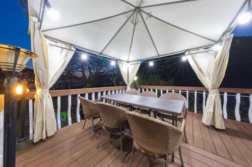 a wooden deck with a wooden table and chairs at Buan Sonamuae Geolin Noeul Pension in Buan