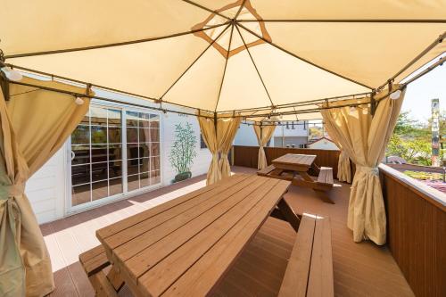 a porch with a wooden table and a tent at Buan Sonamuae Geolin Noeul Pension in Buan