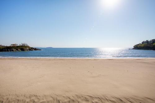 a sandy beach with the ocean in the background at Buan Sonamuae Geolin Noeul Pension in Buan