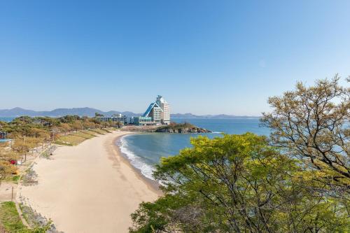 a view of a beach with a building in the distance at Buan Sonamuae Geolin Noeul Pension in Buan