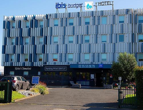 a building with a car parked in front of it at Ibis Budget Le Havre Les Docks in Le Havre