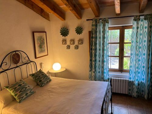 ein Schlafzimmer mit einem großen Bett und einem Fenster in der Unterkunft Agroturismo Son Penyaflor in Alaró