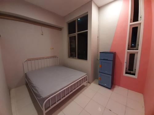 a small bedroom with a bed and a blue dresser at New Jasmine in Karangtengah
