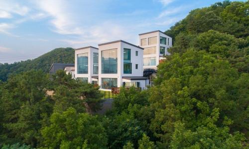 a house on top of a hill with trees at Yangpyeong River Legend in Yangpyeong