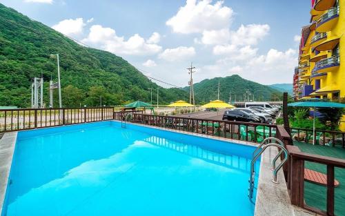 a large blue swimming pool in front of a building at Inje Tourist Hotel in Wŏrhang-ni