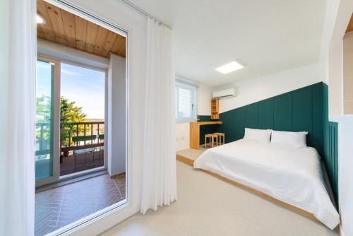 a bedroom with a bed and a large window at Gyeongju Insta Spa Pension Spa, Individual BBQ in Gyeongju